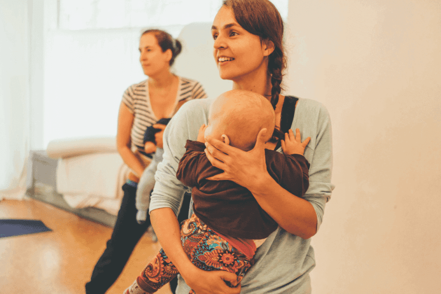 Zwei Frauen mit Baby tanzen im Rückbildungskurs