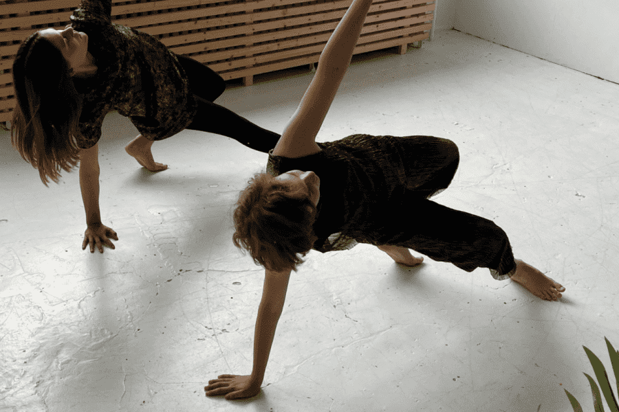 Zwei Mädchen im Teenageralter tanzen Bodenfiguren