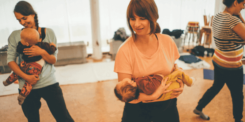 Eine Mama hält ihr Neugeborenes im Rückbildungskurs