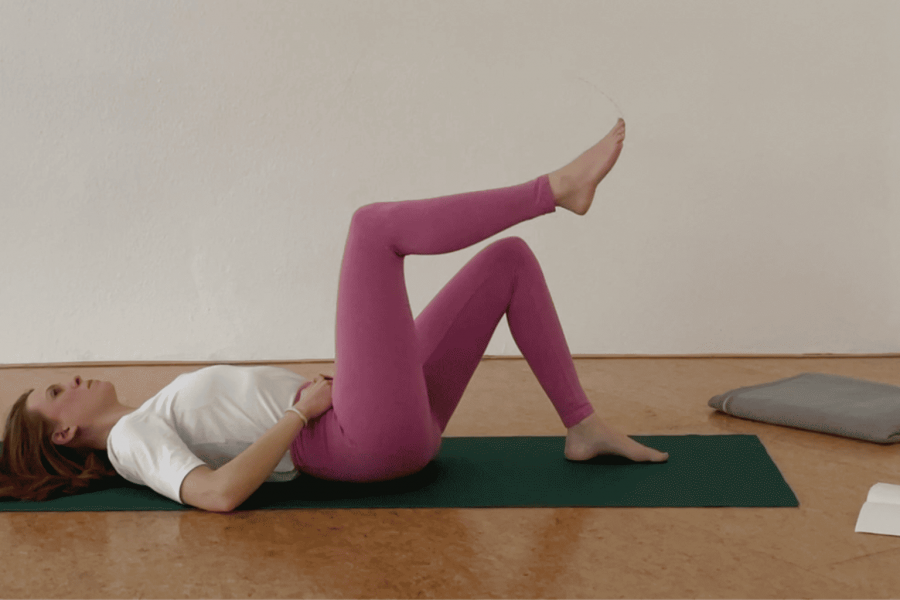 Yogalehrerin mit pinker Leggings in Rückenlage
